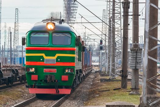 Green diesel cargo locomotive. Freight train in action