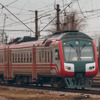 Red diesel passenger train driving at the old terminal