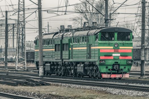 Green diesel cargo locomotive. Freight train in action