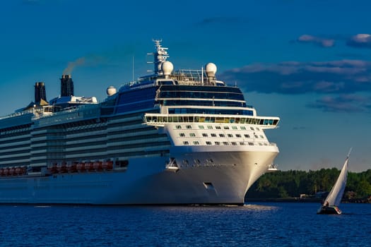 White giant brand new passenger ship moving in clear summer day