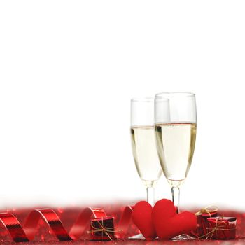 Glasses with Champagne and handmade hearts on red glitters isolated on white background