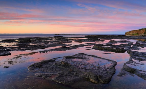 Tidal reflections along the exposed rockshelf on the coast at Geroa Australia