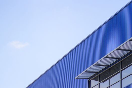 Building of blue wall and window mirror on blue sky