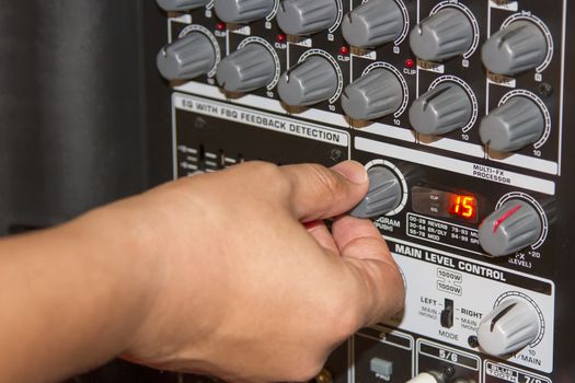 Hand adjusting volume sound of mixer