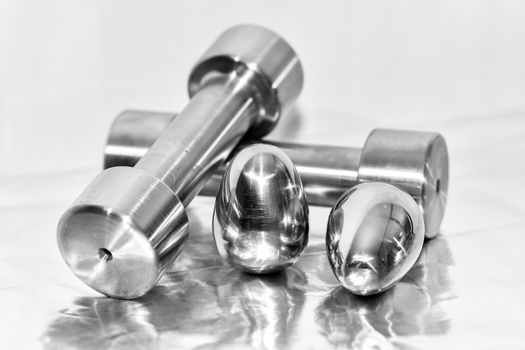 Metal dumbbells and steel eggs, the concept of sports training and the achievement of muscle strength.