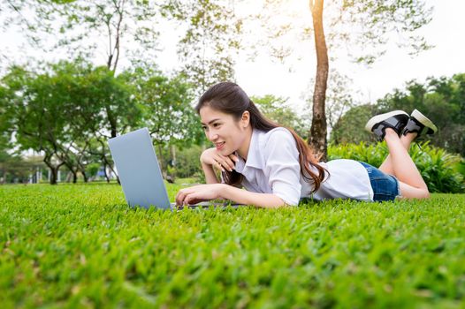Young woman using laptop in park.