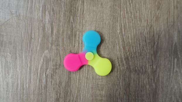 Playing with the colorful Fidget Spinner. Toy
