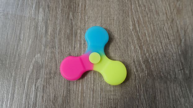 Playing with the colorful Fidget Spinner. Toy