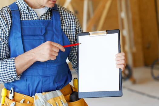 Worker pointing at a clipboard with blank paper, contract concept