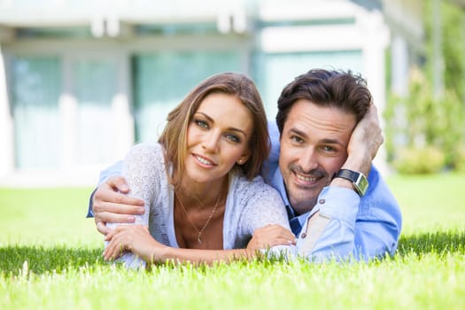 Happy smiling couple laying down in their home garden