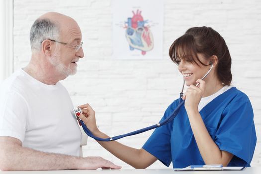 Doctor examining heartbeat of senior male patient