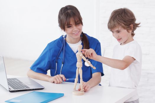 Doctor explain medicine to child using wooden doll