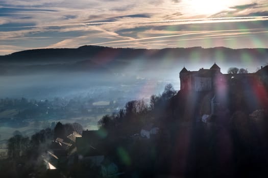 Castle in France during sunset with small town on background