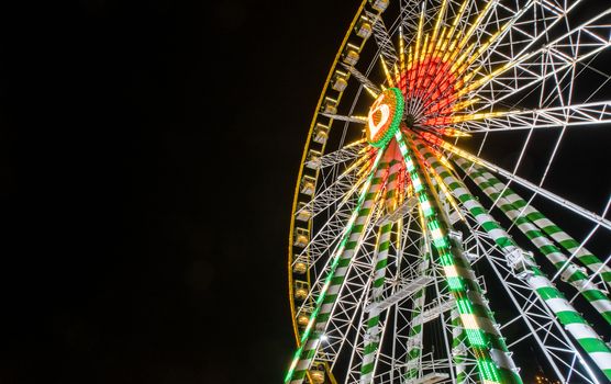 Ferris wheel on pitch black night background in germany at low angle of view