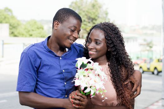 These two young people embracing, stare with beautiful smile,