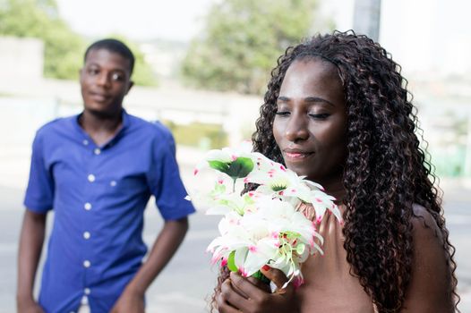 young woman with closed eyes, accepts her flower bouquet with pleasure and love.