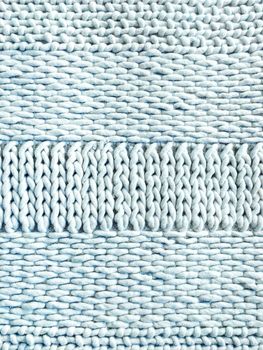 Light blue winter knitted background with simple ornament.
