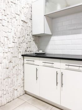 Contemporary kitchen with white cabinets and walls. Home renovations.