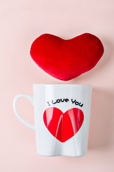 Valentine's Day Concept. Love cup with red heart on pink Background.