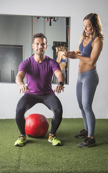 Woman encouraging man partner doing squats