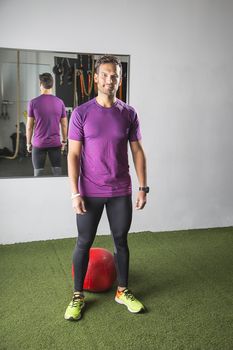 Man in his thirties, standing in front of a red medicine ball