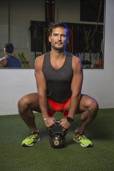 young man about to pull on a black kettlebell