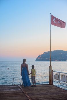 mother and son on the pier in the evening at Alania, Turkey