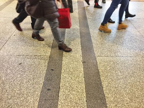 feet of people walking on a striped street in the city