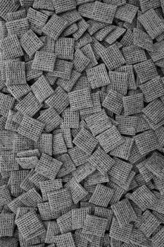 Malted shredded wheat biscuits breakfast cereal as an abstract background texture - monochrome processing