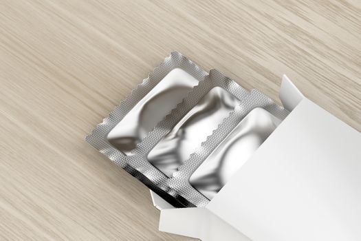 White box with three condoms inside on wooden table