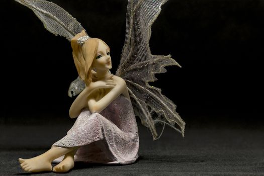 red hair fairy figurine while sitting