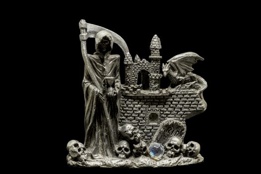 metal figurine of reaper with skulls