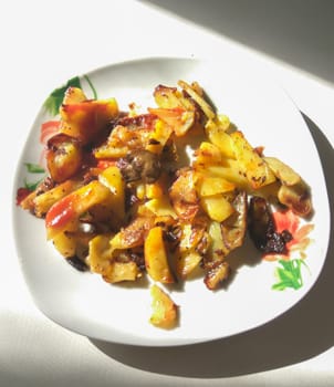 Fried potatoes with mushrooms on a plate