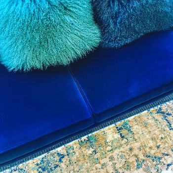 Luxurious sheepskin cushions decorating a blue velvet sofa.