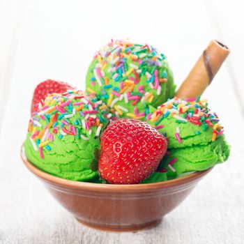 Matcha ice cream in bowl on wooden background.
