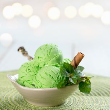 Bowl of mint ice cream on wooden background.