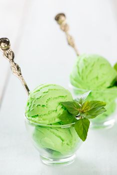 Cup of matcha ice cream on wooden background.
