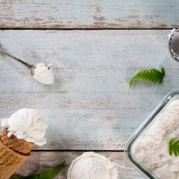 Top view coconut ice cream wafer cone on white rustic wooden background. Copy space in middle.