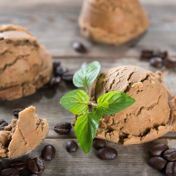 Close up brown ice cream and coffee beans on old rustic vintage wooden background.