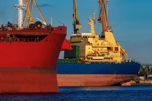 Red and blue cargo ship loading in the port of Riga