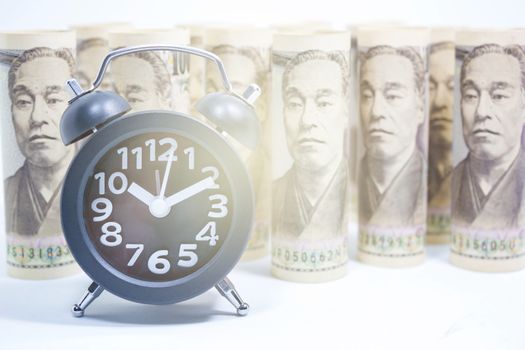 Classic Clock On Roll Of Yen Banknote, Concept And Idea Of Time Value And Money, Business And Finance Concepts, Money market in Asian