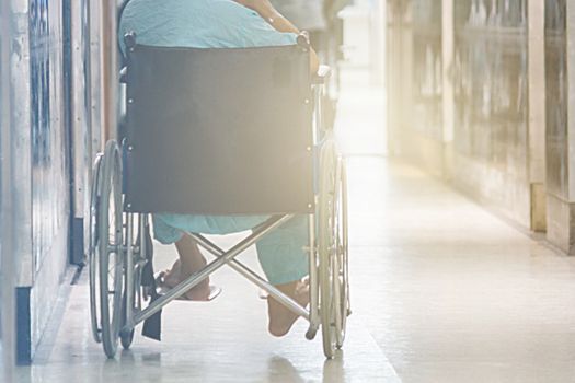 Abstract Of Man On Wheelchair In Front Of The Outpatient Department Of Hospital With Softlight.