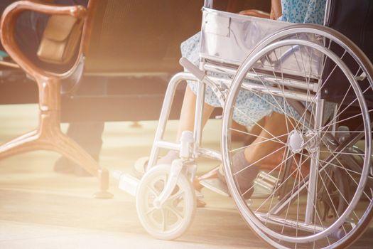 Abstract Of Woman On Wheelchair In Front Of The Outpatient Department Of Hospital With Softlight.