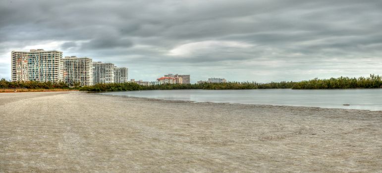 Buildings in the distance on Marco Island, Florida, beach under an overcast sky in winter