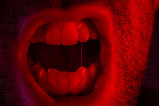 Macro closeup on man shouting with mouth wide open. Portrait with angry facial expression.