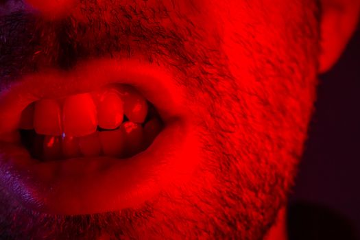 Man with angry facial expression. Macro close up portrait of a man with bared teeth.