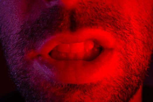 Man with angry facial expression. Macro close up portrait of a man with bared teeth.