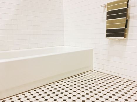 New bathroom with black and white ceramic tile decor and a striped towel on the wall.