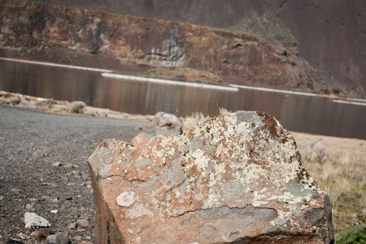 Red desert stone with river and cliff in the background