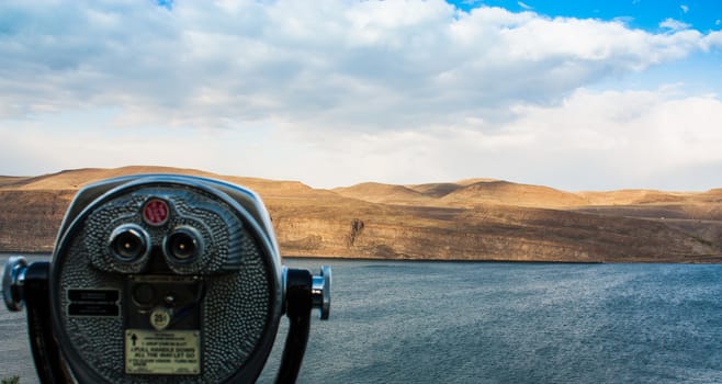 Scenic desert river view showing coin-op binoculars